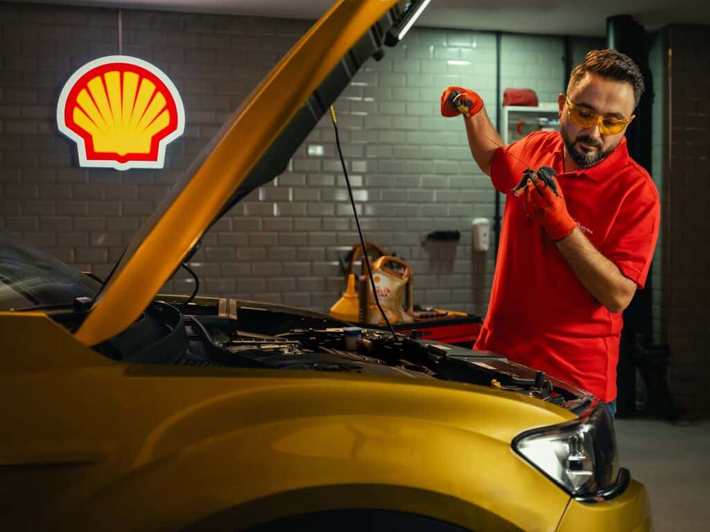 mehanicar menja ulje u automobilu